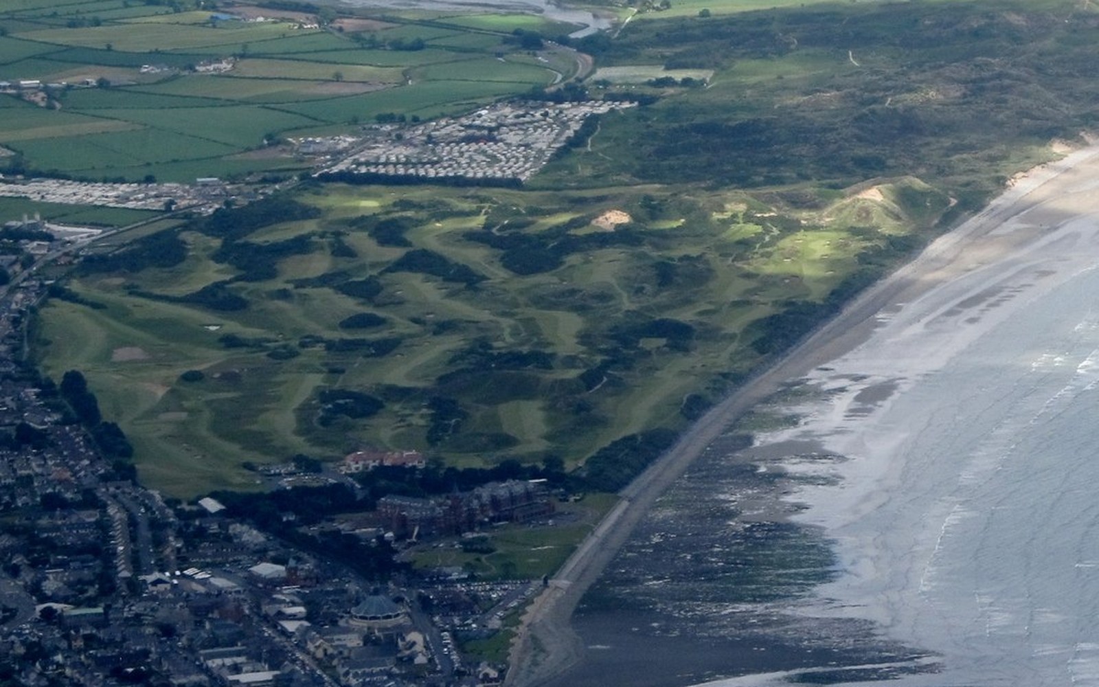 Revetted pot bunker at Royal County Down, stacked marram-turf courses on the face, Slieve Donard and the Mournes in the background